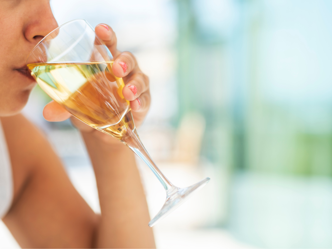 mujer tomando vino blanco